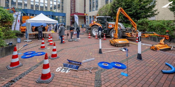 Blick in den Innenhof der LBM-Zentrale: ein Parcours ist mit Leitfposten, Verkehrskegeln markiert. Im Hintergrund ein Fahrzeug mit Mähaufsatz und ein Pavillon